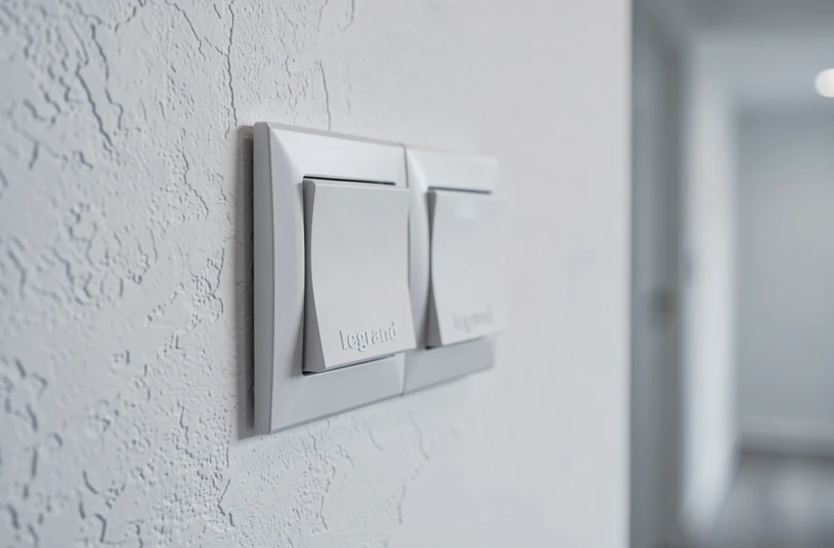 Interrupteur va-et-vient Legrand Céliane double blanc installé sur un mur de couloir rénové